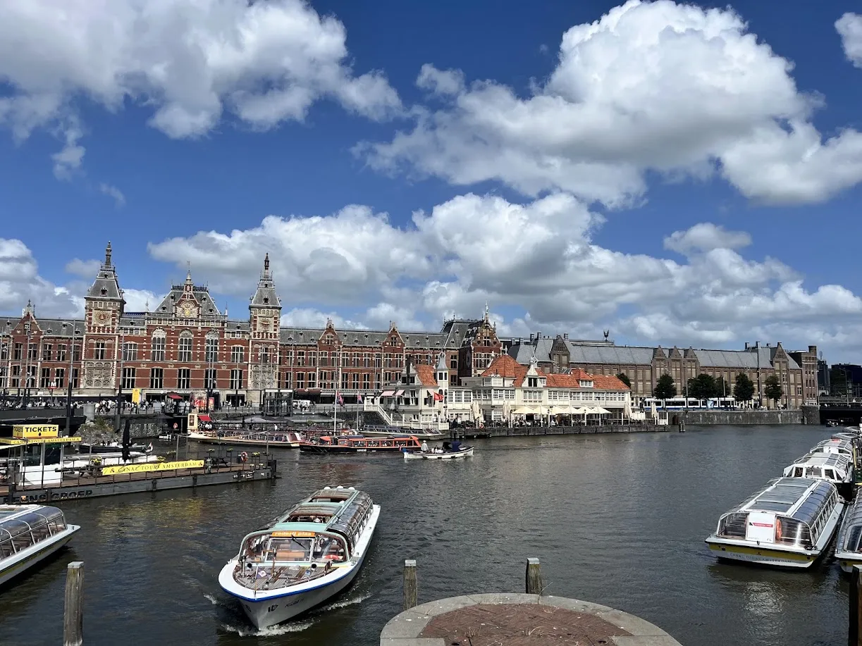 Estación Amsterdam Centraal vista desde el agua, con barcos turísticos