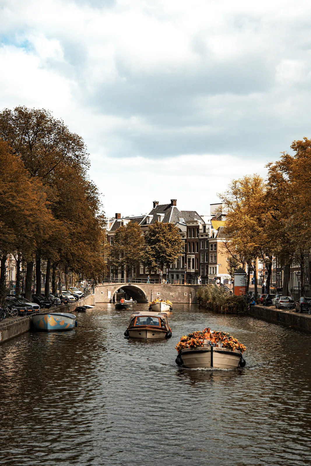 Canal de Ámsterdam con botes turísticos, en otoño