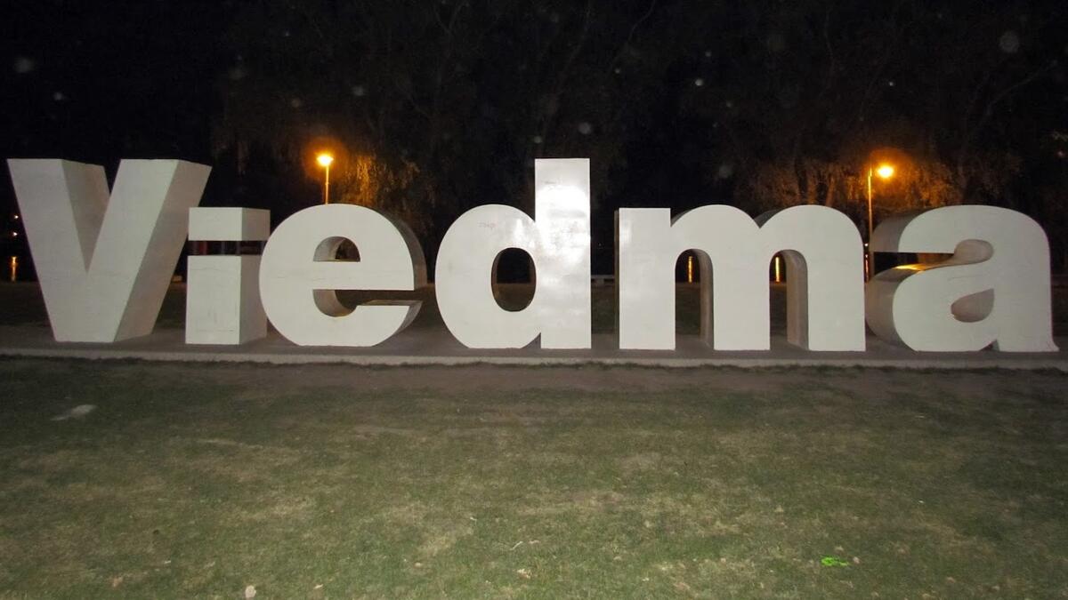 Cartel de Viedma de noche en la costanera