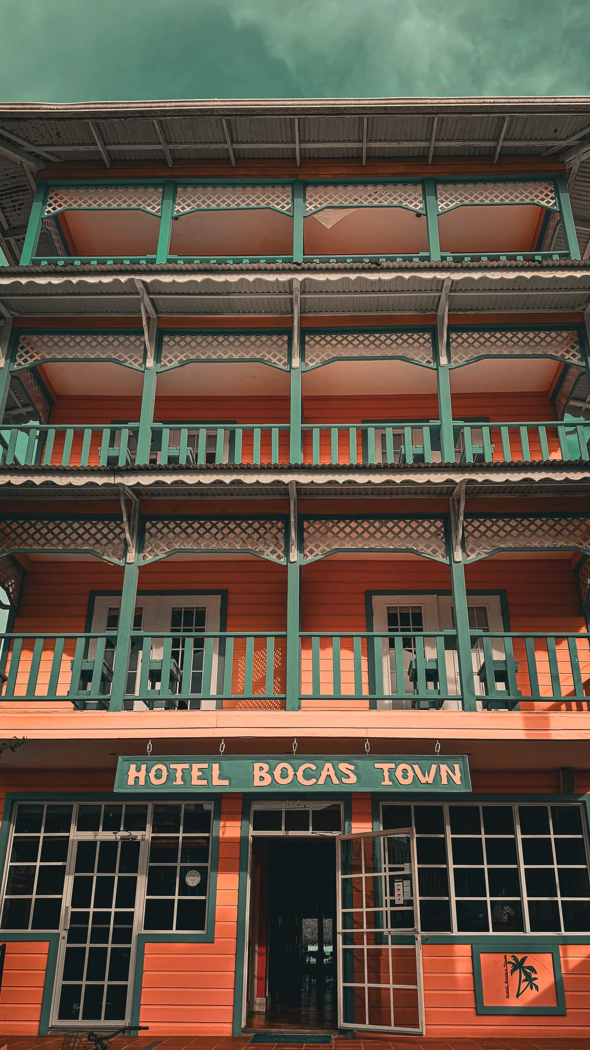 Fachada del Hotel Bocas Town con sus balcones coloridos de madera verde y roja