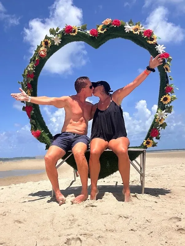 Pareja en la playa de Praia dos Carneiros junto a la capilla