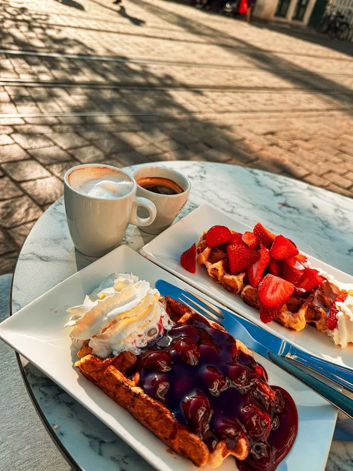 Wafles belgas con frutillas y salsa de frutos del bosque junto a un café, Gante