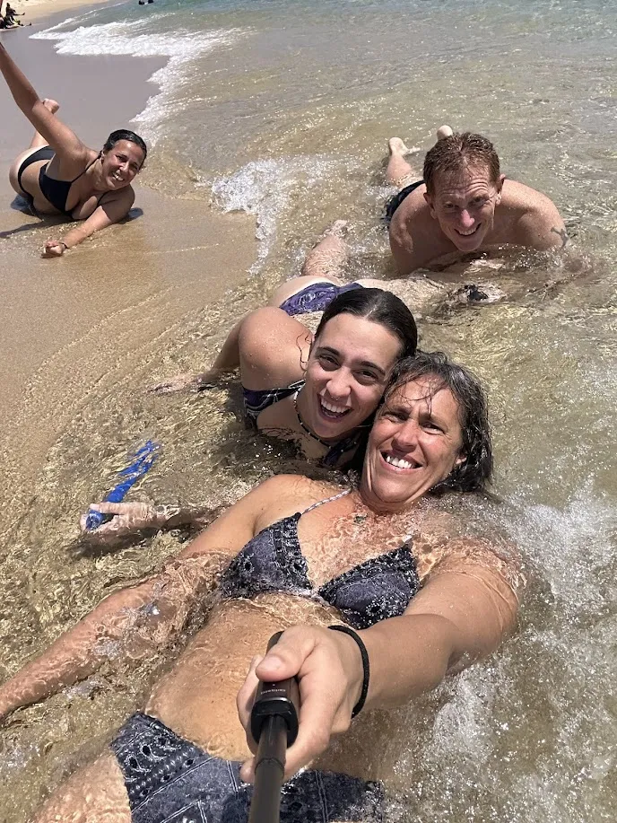 La familia tendida y jugando en la orilla de las bahías durante el tour de las 9 bahías