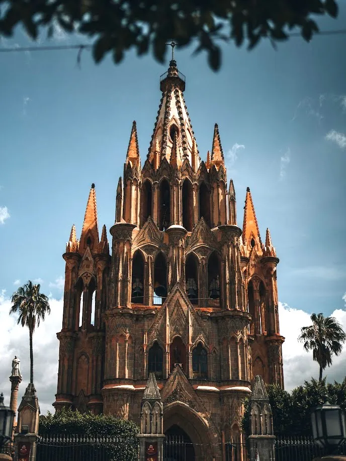 La Parroquia de San Miguel Arcángel con sus torres neogóticas rosadas bajo el cielo azul