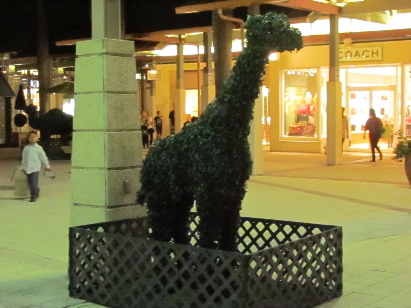 Escultura de jirafa hecha con plantas (topiario) en el shopping The Falls de Miami