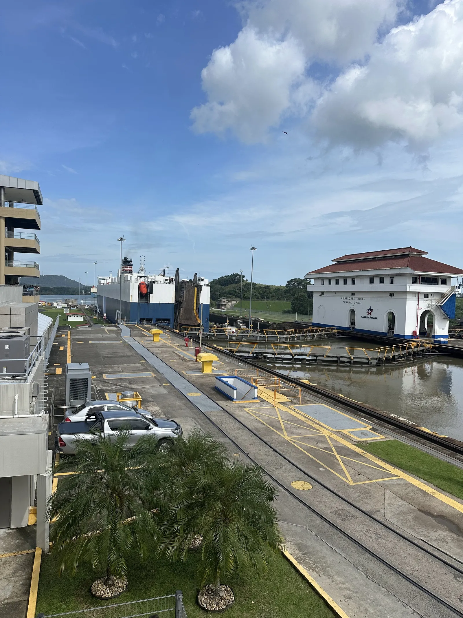 Esclusas de Miraflores del Canal de Panamá con un barco de carga entrando, el edificio histórico y las vías de las mulas