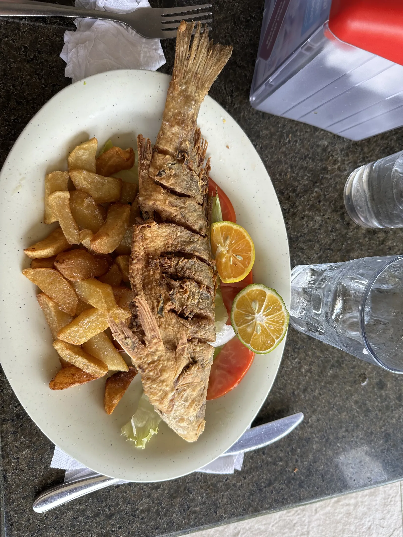 Mojarra frita entera con papas y limón, plato típico de la gastronomía panameña