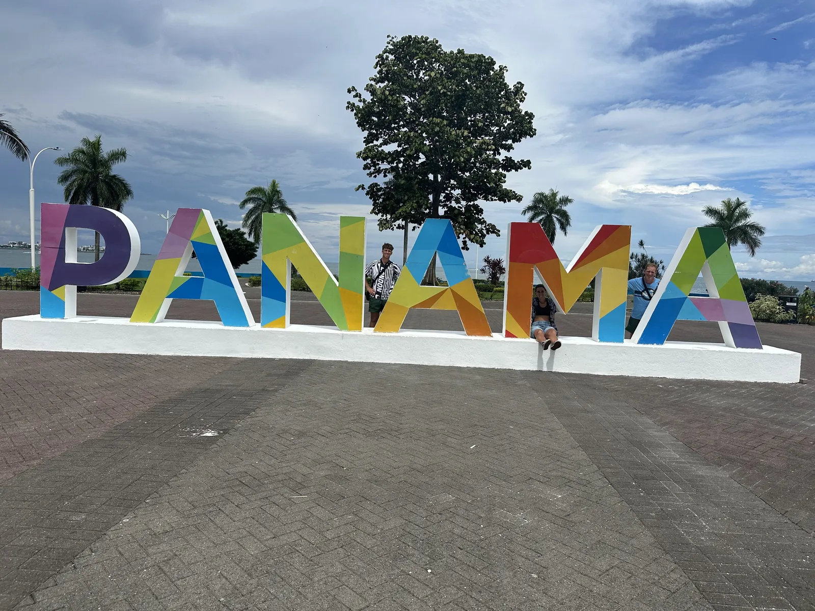 La familia posando frente al enorme letrero colorido PANAMÁ en la Cinta Costera