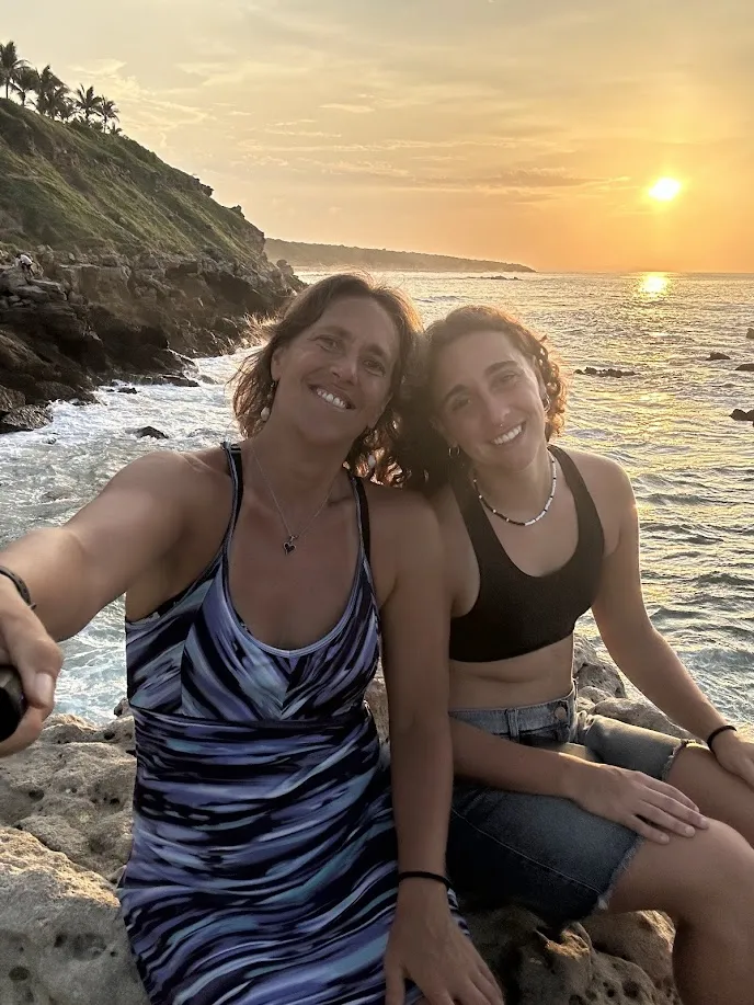 Dani y Agus en el mirador de Mazunte al atardecer con las rocas y el mar dorado de fondo